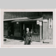 Elderly woman stands in front of building (ddr-densho-348-14)