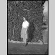 Mae Miwa standing for photo in front of ivy-colored wall (ddr-densho-475-94)