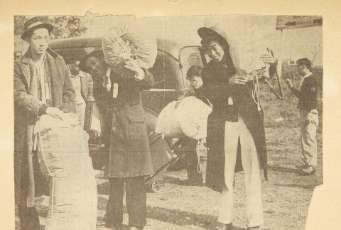 Newspaper clipping of photo of mass removal from scrapbook page (ddr-densho-72-16)