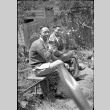Two men sitting on a bench in garden, smoking (ddr-densho-426-1838)