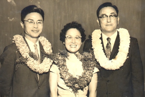 Two men and a woman wearing leis (ddr-njpa-4-43)