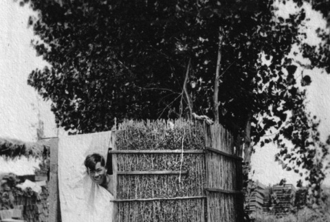Man looking out from outdoor shower (ddr-ajah-6-587)