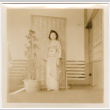 Tomoye (Nozawa) Takahashi in kimono standing in front of screen (ddr-densho-426-2140)