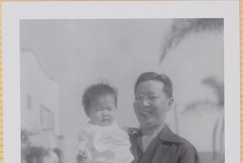 Man holding Leslie Shiomi (ddr-densho-522-403)