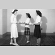 Two women handing a nurse trays of food (ddr-fom-1-637)