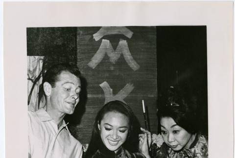 Mary Mon Toy with two cast mates looking at a script (ddr-densho-367-297)
