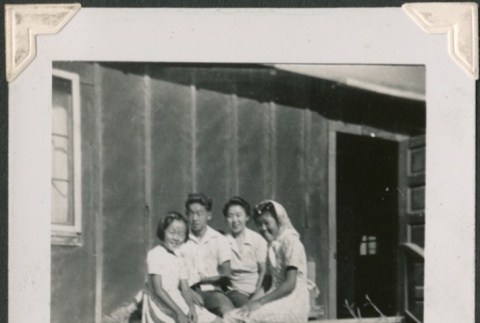 Group sitting on a porch in camp (ddr-densho-321-170)