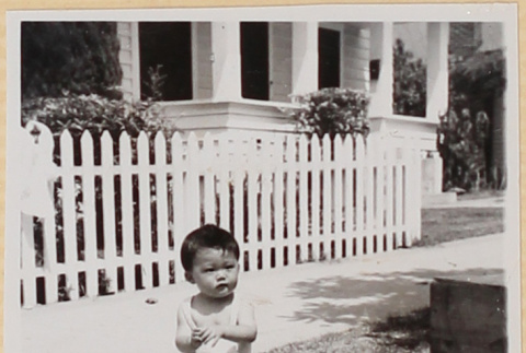 Small child sitting on lawn outside house (ddr-densho-522-17)