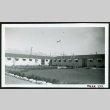 Photograph of the Manzanar administrative buildings with a flag flying (ddr-csujad-47-156)