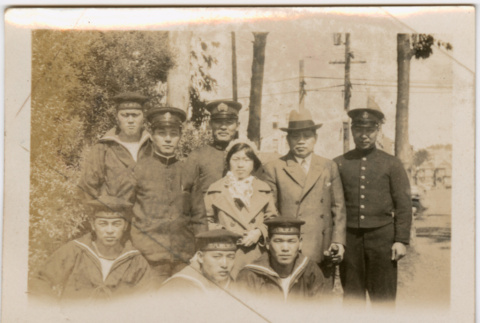 Tomoyuki Nozawa and girl (possibly Martha) standing with group of men in Japanese naval uniforms (ddr-densho-426-2029)