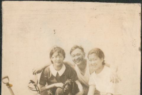 Two women, a man and dog with bucket of razor clams (ddr-densho-523-45)