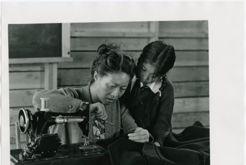 Still scene of Misa Wakatsuki (Nobu McCarthy) sewing for Jeanne Wakatsuki (Dori Takeshita) (ddr-densho-317-6)