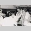 Couple wearing leis being welcomed at the Honolulu Airport (ddr-njpa-2-224)