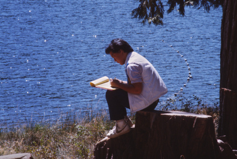 Paul Osaki writing at the lake (ddr-densho-336-1479)