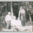 Chester Sakura Sr., with two men and a woman sitting on log (ddr-densho-523-338)