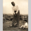 A man posing with golf club, young child seated nearby (ddr-njpa-4-98)