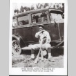 Baseball player sitting in front of a car (ddr-manz-10-152)