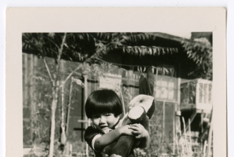 Young girl with rabbit toy (ddr-densho-475-353)