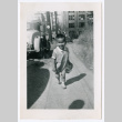 Photo of a child walking down a sidewalk (ddr-densho-483-734)