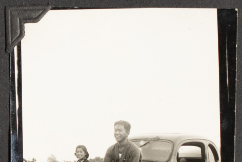 Yosh Kikawa sitting on the hood of a car (ddr-densho-542-364)
