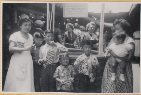 Two women and five children by wishing well (ddr-densho-522-343)