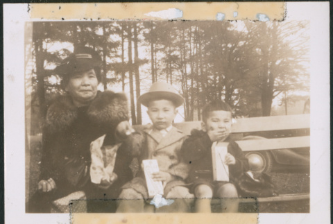 Woman and two children sitting on a bench (ddr-densho-483-1092)