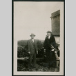 Two men in suits pose by car (ddr-densho-359-726)