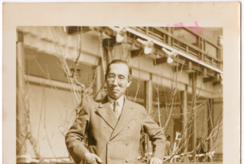 Man standing by railing of large building (ddr-densho-426-2042)