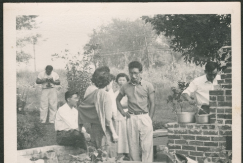 Group standing by outdoor grill (ddr-densho-293-135)