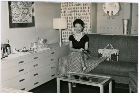 Mary Mon Toy sitting on couch in a stateroom (ddr-densho-367-162)