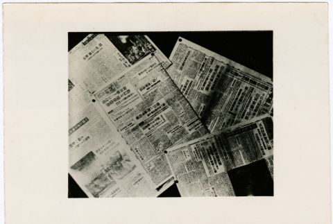 Stack of newspapers about Tokyo bombings (ddr-densho-381-114)