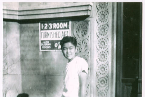 Frank Nishioka in front of apartment building (ddr-densho-292-67)