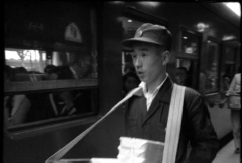 Man selling bento boxes at train station (ddr-densho-426-2299)