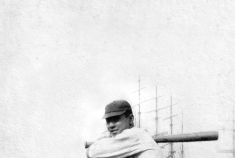Man in baseball uniform with bat and ships in the background (ddr-ajah-5-58)