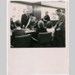 Mary Mon Toy in Esquire offices with group of people around table (ddr-densho-367-305)