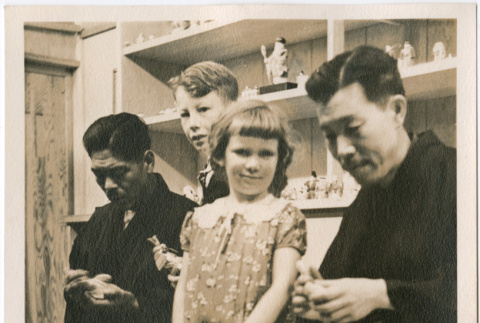 Boy and girl watching two men demonstrating carving at Japanese Pavilion at the Golden Gate International Exposition (ddr-densho-426-2088)