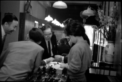 Group standing around counter in shop (ddr-densho-426-2404)