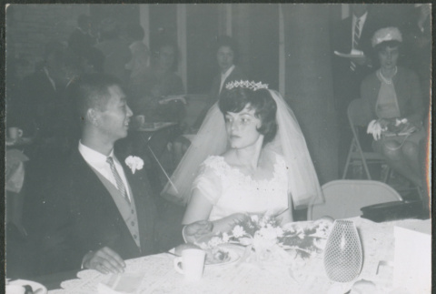Bride and groom at a table at reception (ddr-densho-523-352)