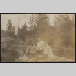 Two men and a woman sitting on a log (ddr-densho-355-659)
