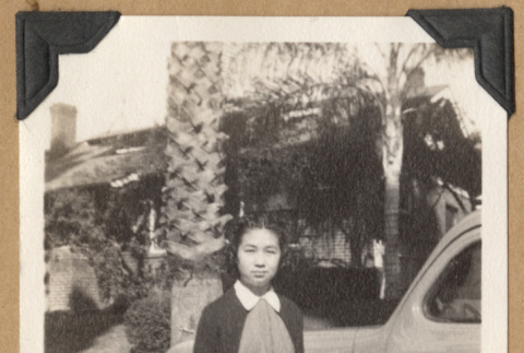 Girl stands next to a car (ddr-densho-542-210)