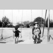 Mother and children on swings (ddr-densho-12-8)
