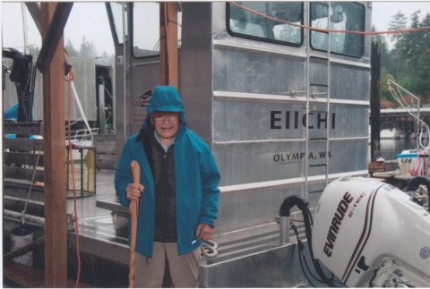 Eiichi Yamashita standing next to an oyster barge (ddr-densho-296-116)
