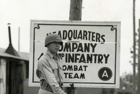 Soldier standing in front of a 442nd sign (ddr-densho-22-475)