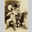 Wiley Post sitting in front of his plane in a pressurized suit (ddr-njpa-1-1323)