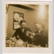 Two men sitting at a table with food (ddr-densho-426-2114)