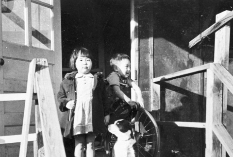 Two children outside barracks (ddr-densho-15-49)
