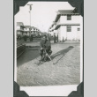 Man kneeling next to mortar with barracks in background (ddr-ajah-2-136)