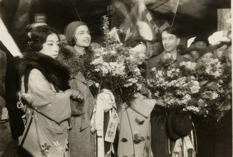 A man and woman being greeted with bouquets (ddr-njpa-1-1885)