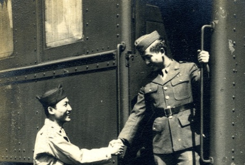 Soldiers shaking hands at a train station (ddr-densho-22-183)
