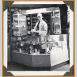 Man standing behind a display (ddr-densho-542-111)